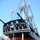 170613-N-HQ322-005 The image shows the USS Constitution, a historic wooden-hulled sailing frigate, in dry dock undergoing maintenance or restoration. The ship is supported by wooden and metal bracing structures, with its hull fully exposed and draft markings visible on the bow. An American flag flies from the bowsprit, and workers with a lift platform are visible near the hull.