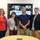 170607-N-HN707-345 Four individuals are posing together in what appears to be a conference or presentation room. Behind them is a large display screen showing a presentation slide about 'Behavioral and Life Risk Factors' related to suicide deaths, along with military-themed images. A research poster is visible on the wall to the right.