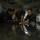 170613-N-VN584-103 Three individuals wearing dark navy blue uniforms are gathered around a highly reflective surface inside what appears to be a military vessel or industrial workspace. They appear to be examining or working on something on the surface, with one person holding a tool. The low-angle shot captures their reflections on the polished surface below.