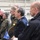 170614-N-JI086-354 A group of military and civilian personnel are gathered at what appears to be a NATO-related event or briefing, likely aboard a naval vessel or military facility. Several individuals are wearing military uniforms with visible national insignia including German Bundeswehr camouflage, Swedish flag patches, and Polish flag patches. A small NATO flag is visible in the foreground, indicating a multinational military gathering.