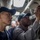 170612-N-MJ135-122 Two military personnel, appearing to be U.S. Navy sailors based on their uniforms and caps, are conducting an inspection or maintenance check in what appears to be a ship's interior compartment. One sailor is using a flashlight to illuminate an overhead area while the other observes closely. Additional personnel are visible in the background.