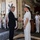 170613-N-FM530-005 A formal greeting ceremony is taking place aboard a U.S. Navy ship designated as an LPD (Landing Platform Dock). A civilian in a dark suit is shaking hands with a senior naval officer in white dress uniform, while other naval personnel in working uniforms stand at attention in the background. A 'WELCOME' sign with a naval anchor insignia is visible on the bulkhead behind them.