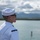 170614-N-BL637-042 A U.S. Navy sailor in dress white uniform stands at attention or at ease near a body of water, gazing into the distance. The sailor's shoulder patch reads 'USS Carl Vinson,' identifying their assigned vessel. The setting appears to be a harbor or bay with mountains and cloudy skies in the background.