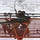 USS Blue Ridge Sailors give the ship a new coat of paint A worker is positioned in an orange aerial lift basket, performing maintenance or repair work on a large white surface overhead, likely the fuselage or exterior of an aircraft or large structure. The worker is looking upward and using a tool to apply or remove material from the white surface. The perspective is shot from below, looking up at the underside of the lift platform.