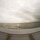 170614-N-GG458-139 A fisheye-lens photograph taken from the bow of a naval vessel named 'ARLINGTON,' looking out over open, choppy ocean water under an overcast sky. The curved bow ramp with chain-link safety netting is prominently visible in the foreground, with the ship's name stenciled in white letters. Several small watercraft or amphibious vehicles are visible in the water ahead of the ship.