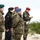 170614-N-PF515-002 A group of Polish military personnel are standing outdoors in a sandy, semi-arid environment with low shrubs in the background. The individuals are wearing Polish Army camouflage uniforms with Polish flag patches, and various colored berets indicating different branches or roles. One individual on the right wears an 'MP' (Military Police) designation patch and a red beret.