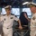 Sterett-Dewey Surface Action Group Deployment Two senior naval officers in white dress uniforms are engaged in conversation aboard what appears to be a ship's bridge or command area. One officer wears insignia consistent with the People's Liberation Army Navy (PLAN) of China, while the other displays insignia consistent with the United States Navy. The setting suggests a formal military exchange or tour of a naval vessel.
