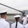 Sterett-Dewey Surface Action Group Deployment A US Navy sailor in white dress uniform is conducting a briefing or tour for a group of naval personnel on the deck of a warship, standing near a large naval gun turret. The group appears to include sailors from at least two different navies, identifiable by slight differences in uniform insignia. The setting appears to be a port visit or exchange event, likely in a Southeast Asian location based on the visible shoreline and vegetation.