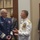 Marine Barracks Washington; EveningParade July 14, 2017 Two senior military officers in dress uniforms are engaged in conversation at what appears to be a formal military event or ceremony. One officer wears a dark blue Coast Guard-style dress uniform with silver sleeve stripes, while the other wears a white Navy dress uniform adorned with numerous medals and gold shoulder boards indicating flag officer rank. Several other individuals, including uniformed personnel and civilians in business attire, are visible in the background.
