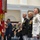 Marine Barracks Washington; EveningParade July 14, 2017 A formal United States Marine Corps ceremony is taking place indoors, likely a change of command or retirement ceremony. Senior military officers in dress uniforms stand at attention alongside civilians, with the USMC organizational colors prominently displayed. Attendees in the background have their hands over their hearts, suggesting the playing of the National Anthem or a similar patriotic observance.