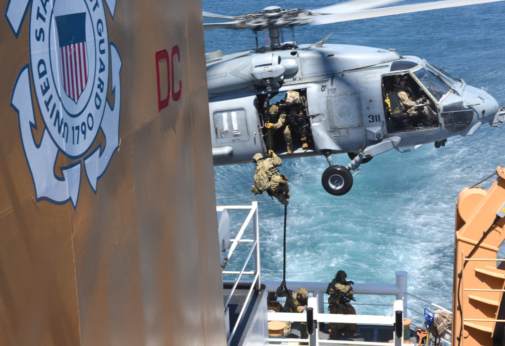 Navy helicopters deploy Coast Guard members onto Coast Guard cutter