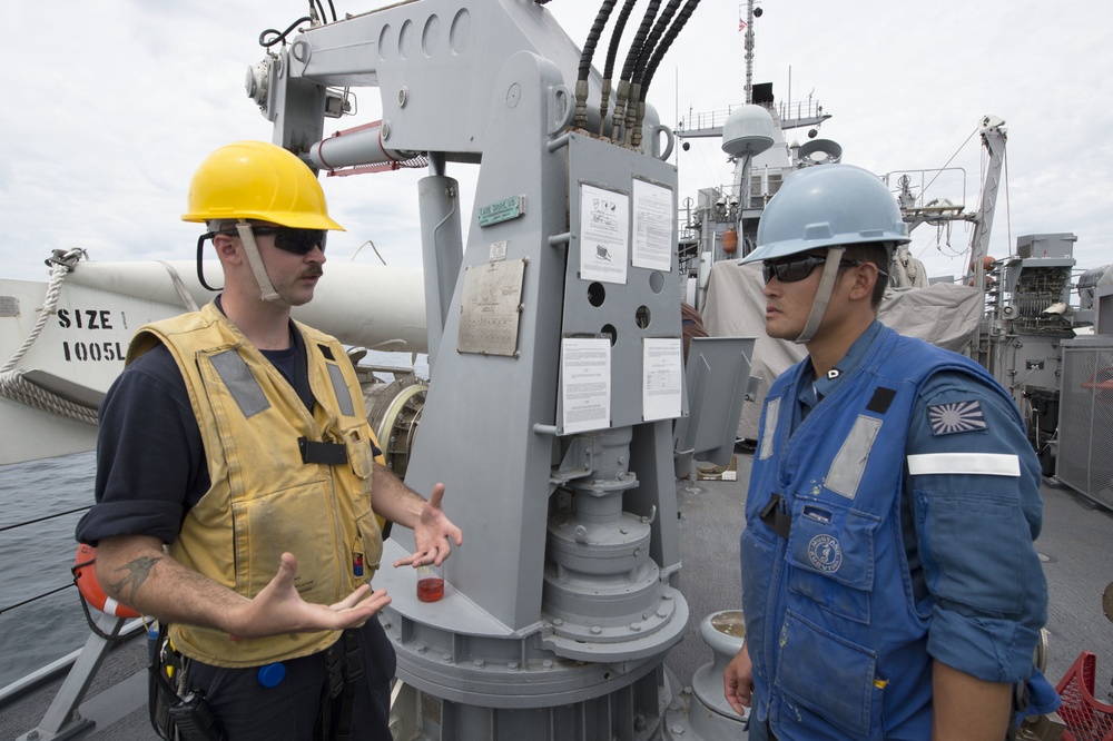 2JA MCMEX Pioneer (MCM 9) sailor speaks with JMSDF sailor