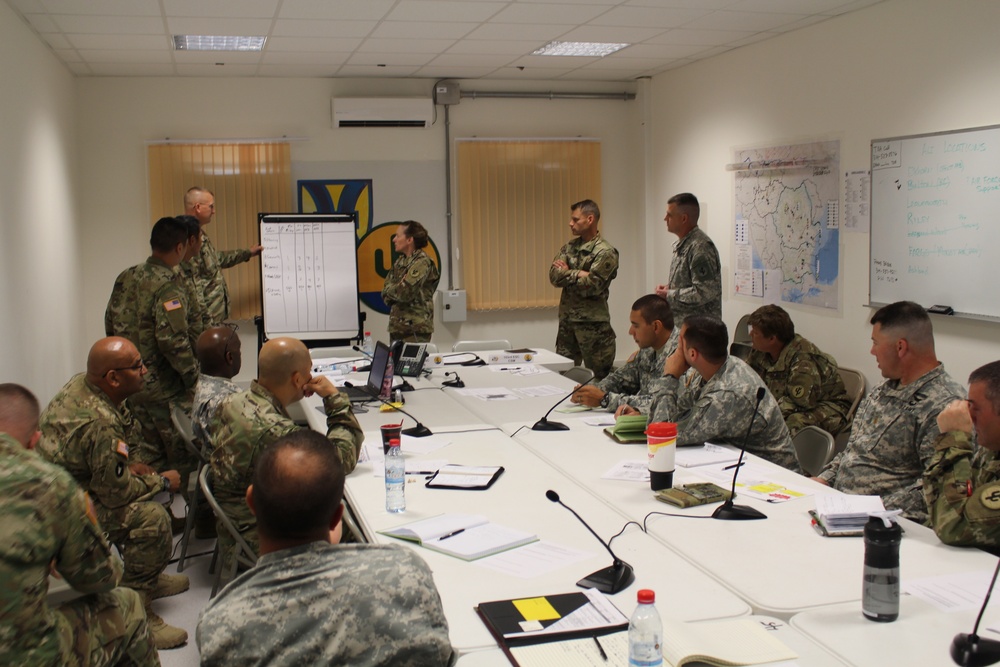 Staff members of the 103rd Expeditionary Sustainment Command make decisions during Saber Guardian 17