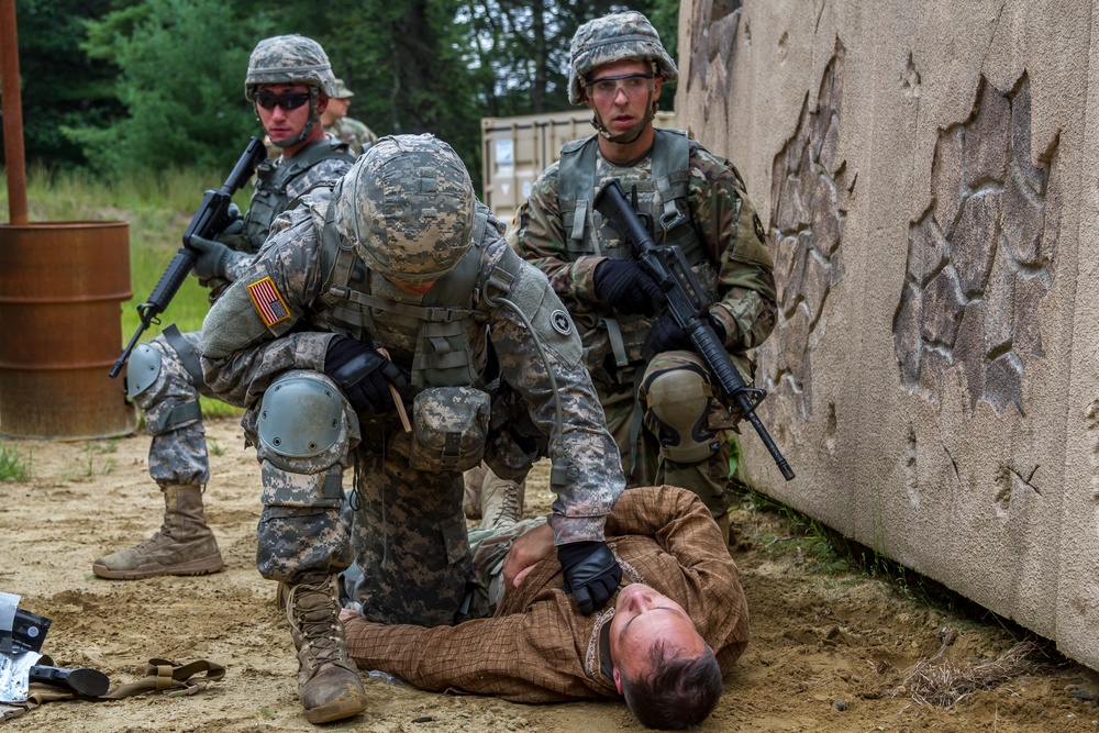 Spc. Kenny Ochoa,provides treatment while Spc. Wantea Seong and Cpl. Carlo Deldonno provide security