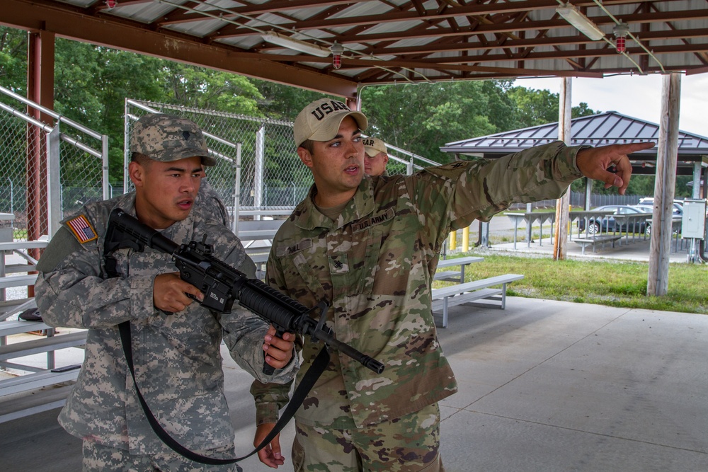 Sgt. Joseph Hall shows Spc. Kenny Ochoa techniques with the M4 rifle