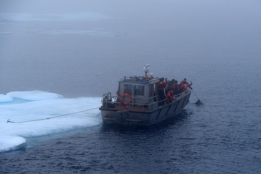 Coast Guard Cutter Healy small boat is anchored to an ice floe during cold water ice dive in the Arctic