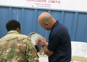 Travis Moore shows Letterkenny Munitions Center’s Advanced Anti-Radiation Guided Missile radome repair capabilities to CSM Tomeka O’Neal, Joint Munitions Command, while Brentley Gamble looks on.