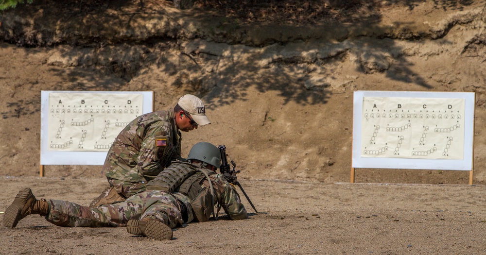 Sgt. Joseph Hall shows Staff Sgt. Jonathan Anderson how to improve accuracy with the M249 squad automatic weapon