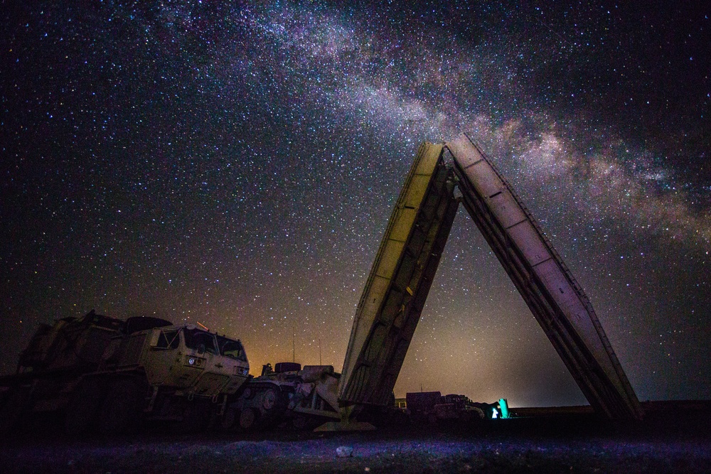 An armored vehicle-launched bridge at night