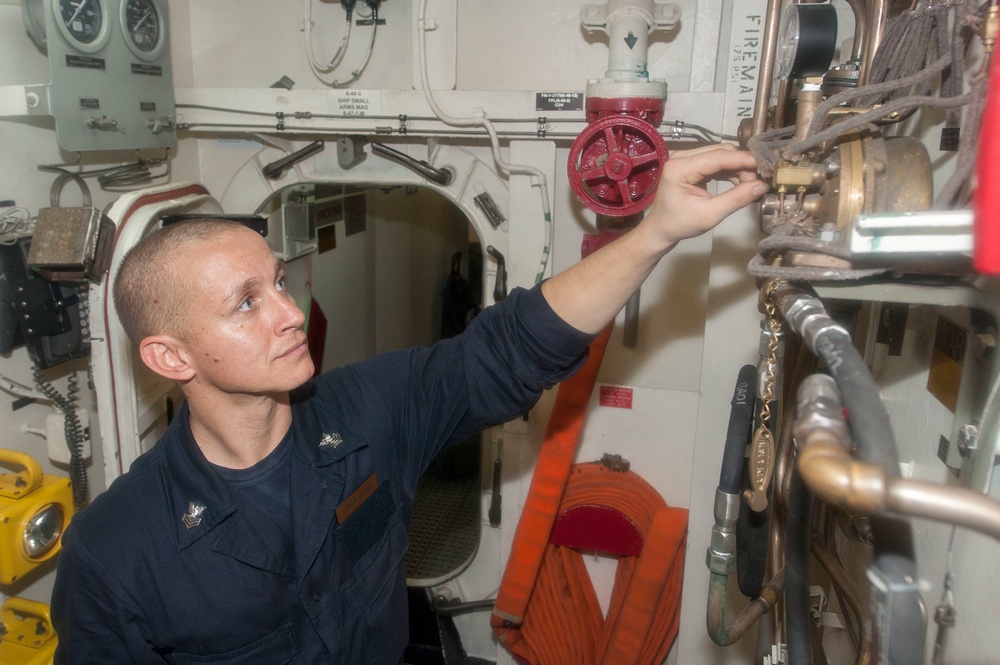 USS America Sailor inspects sprinklers