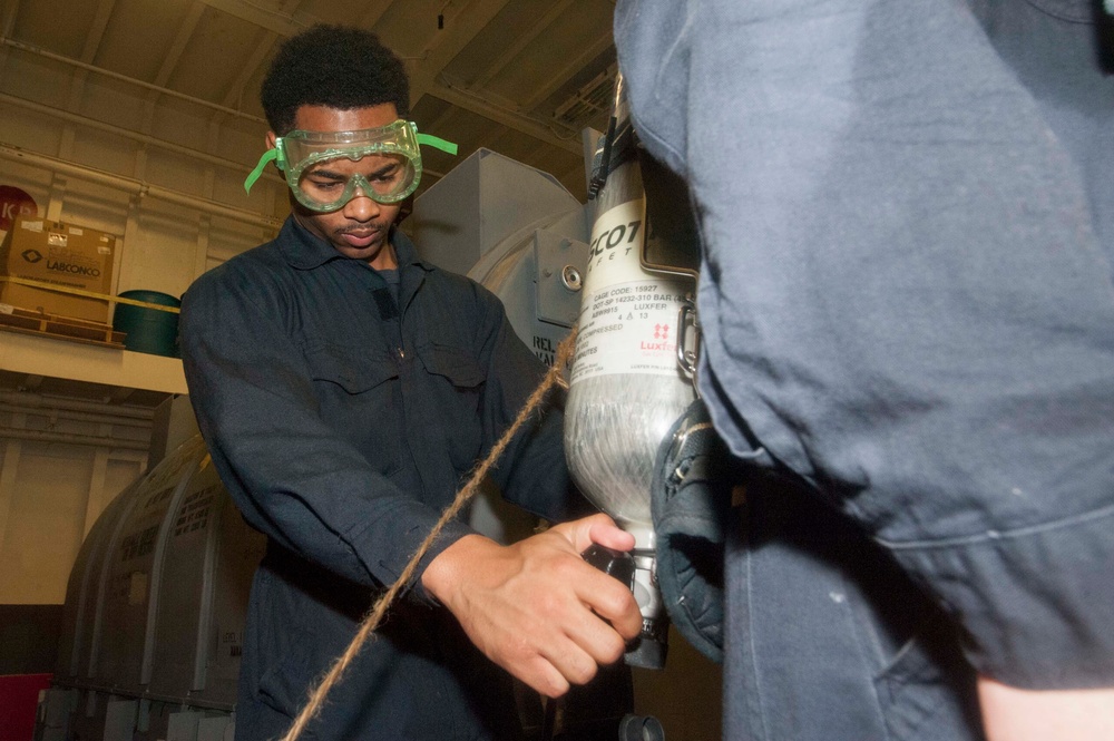 USS America Sailor refills oxygen tank