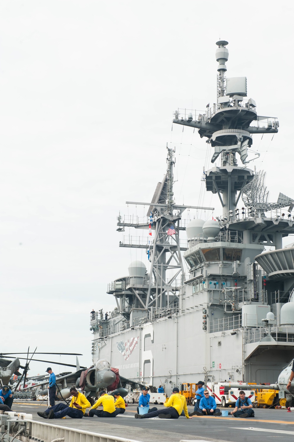 Air department cleans pad eyes on flight deck