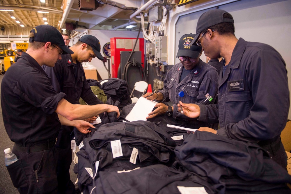 USS America Sailors prepare provisions for USS John S. McCain Sailors