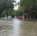 A Coast Guard Flood Punt Team transports a family across a flooded neighborhood