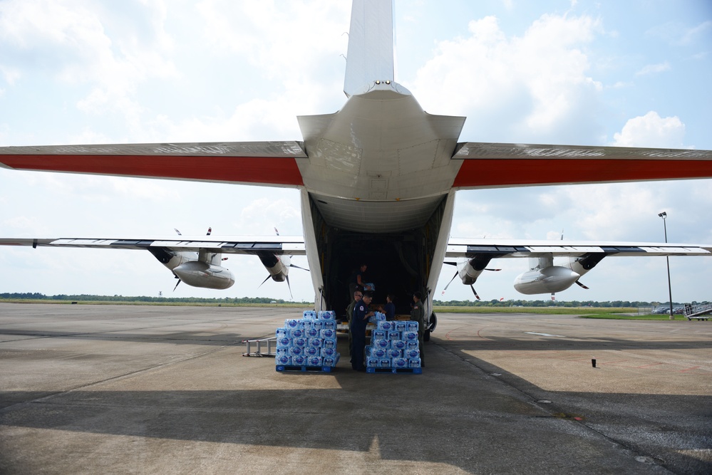 A Coast Guard Air Station Elizabeth City HC-130 aircrew and Marine Safety Unit Port Arthur personnel offload bottled water to aid families affected by Hurricane Harvey