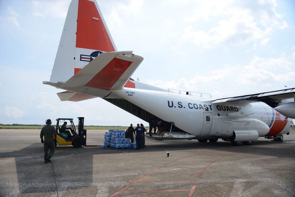 A Coast Guard Air Station Elizabeth City HC-130 aircrew and Marine Safety Unit Port Arthur personnel offload bottled water to aid families affected by Hurricane Harvey