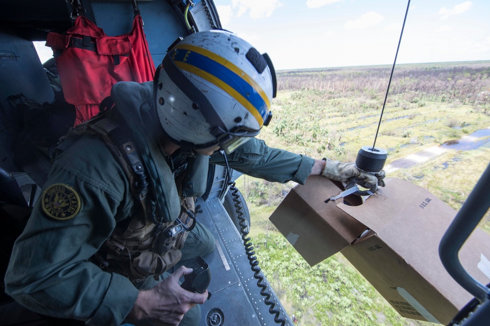 Air Crewman (Helicopter) 2nd Class Sam Jeune, from Grand Rapids, Minnesota, prepares to lower water to residents affected by Hurricane Irma   from an MH-60R Sea Hawk