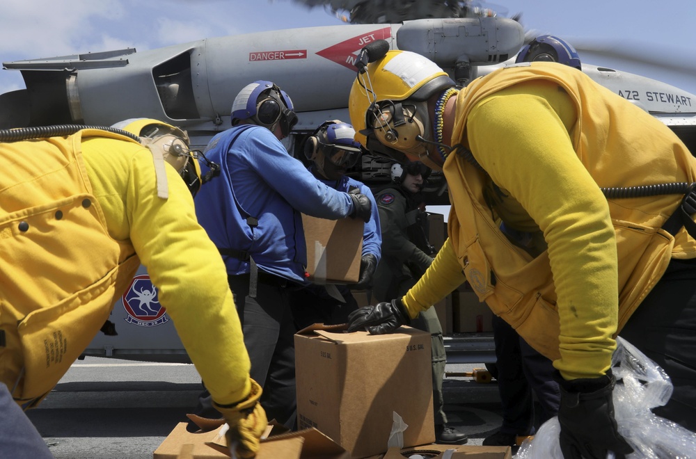 U.S. Navy Sailors assigned to the Nimitz-class aircraft carrier USS Abraham Lincoln (CVN 72) load water into an MH-60S Sea Hawk from the Ghost Riders of  Helicopter Sea Combat Squadron (HSC) 28