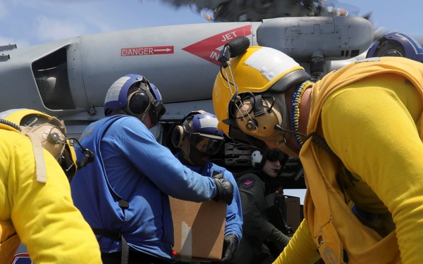 U.S. Navy Sailors assigned to the Nimitz-class aircraft carrier USS Abraham Lincoln (CVN 72) load water into an MH-60S Sea Hawk from the Ghost Riders of  Helicopter Sea Combat Squadron (HSC) 28