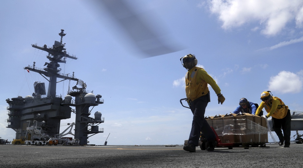 U.S. Navy Sailors assigned to the Nimitz-class aircraft carrier USS Abraham Lincoln (CVN 72) load pallets of water into an MH-60S Sea Hawk helicopter from the Ghost Riders of  Helicopter Sea Combat Squadron (HSC) 28