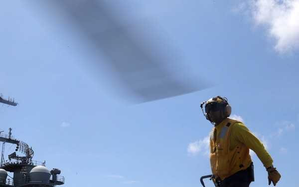 U.S. Navy Sailors assigned to the Nimitz-class aircraft carrier USS Abraham Lincoln (CVN 72) load pallets of water into an MH-60S Sea Hawk helicopter from the Ghost Riders of  Helicopter Sea Combat Squadron (HSC) 28