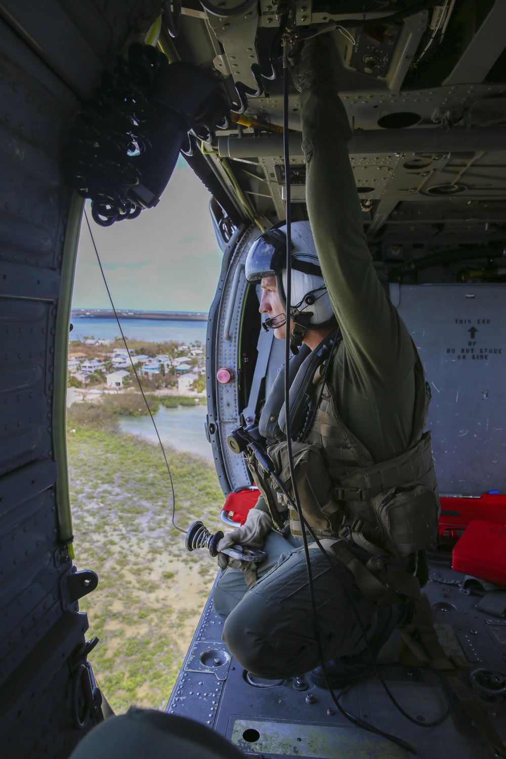 Air Crewman (Helicopter) 1st Class Mike Andrew searches Key West during a reconnaissance mission, inside an MH-60S Sea Hawk, from the Nightdippers of Helicopter Sea Combat Squadron (HSC) 5