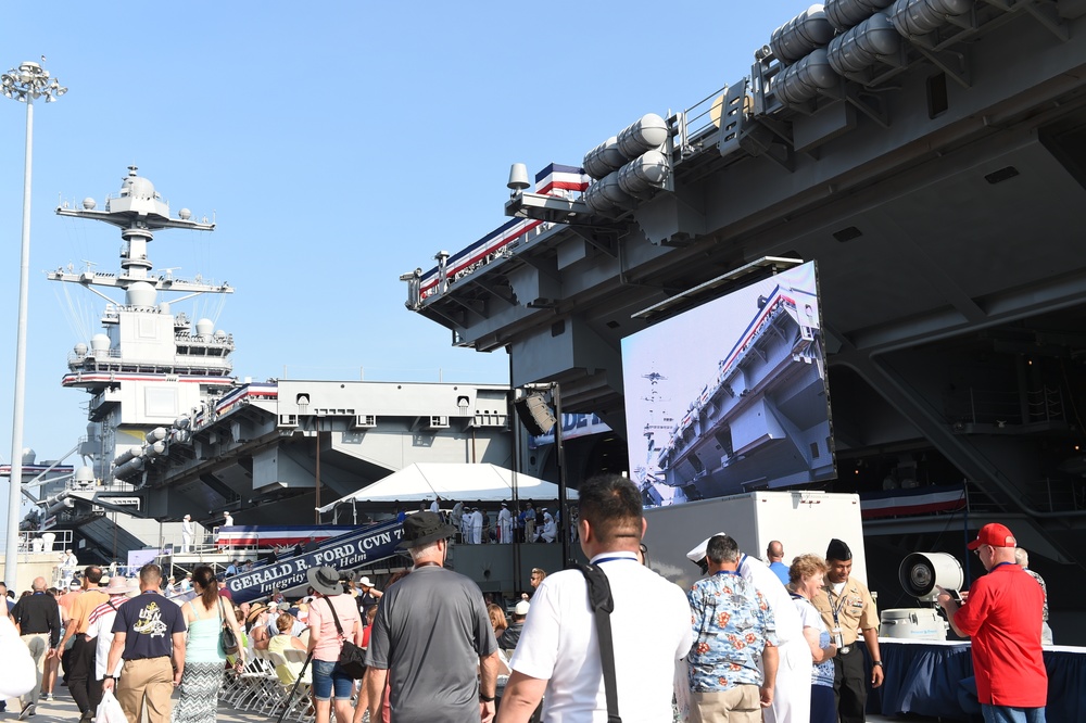 Family, friends and guests of USS Gerald R. Ford's (CVN 78) crew members walk the pier prior to the ship's commissioning ceremony
