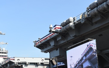 Family, friends and guests of USS Gerald R. Ford's (CVN 78) crew members walk the pier prior to the ship's commissioning ceremony