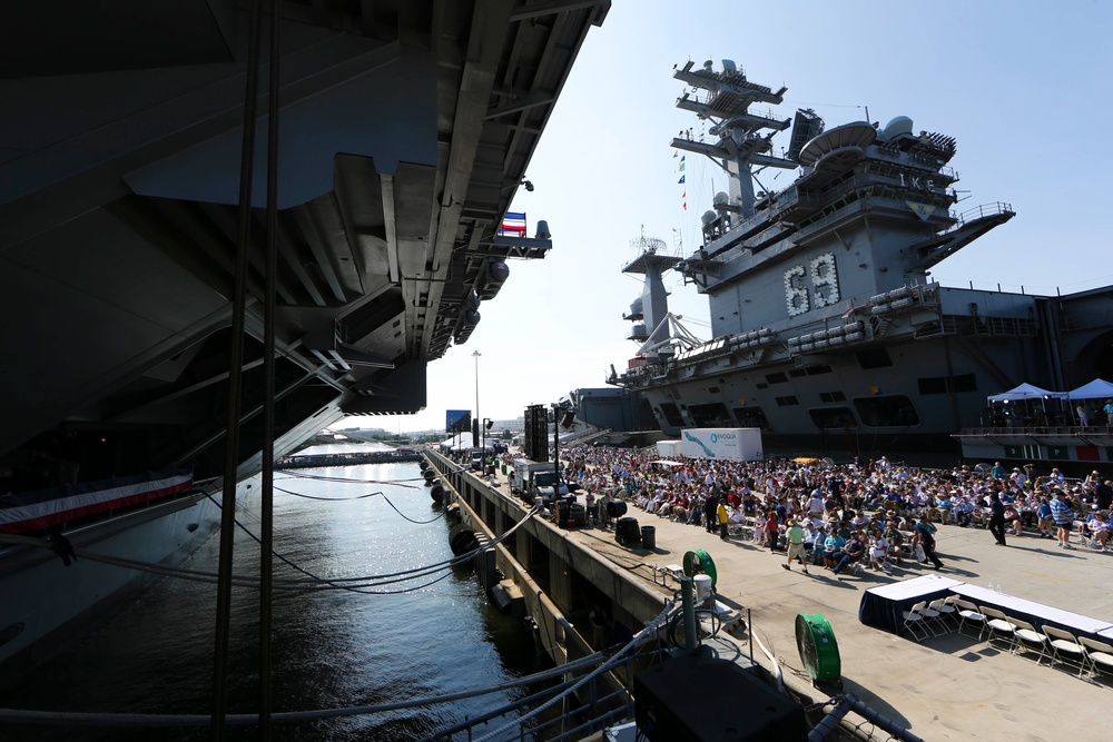 Guests sit on the pier between USS Dwight D. Eisenhower (CVN 69) and USS Gerald R. Ford (CVN 78) to witness Ford’s commissioning ceremony at Naval Station Norfolk