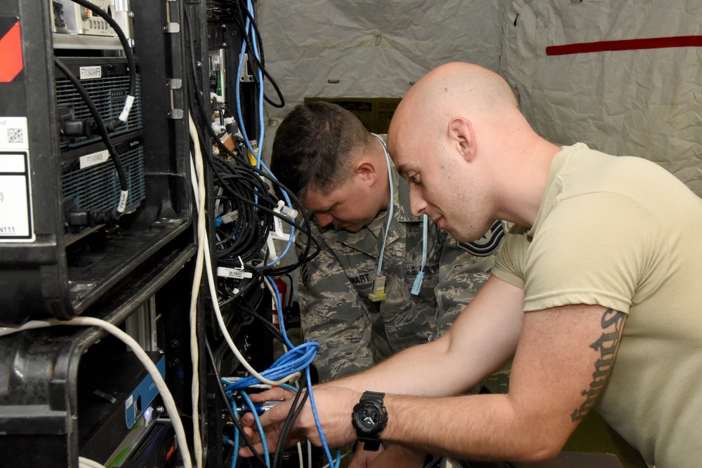 Master Sgt. Edward Stewart and Tech. Sgt. Justin Deal, 269th Combat Communications Squadron connect cables as they set up a wireless internet system at Wright-Patterson Air Force Base, Fairborn, Ohio for the United States Air Force Marathon Sept. 14, 2017