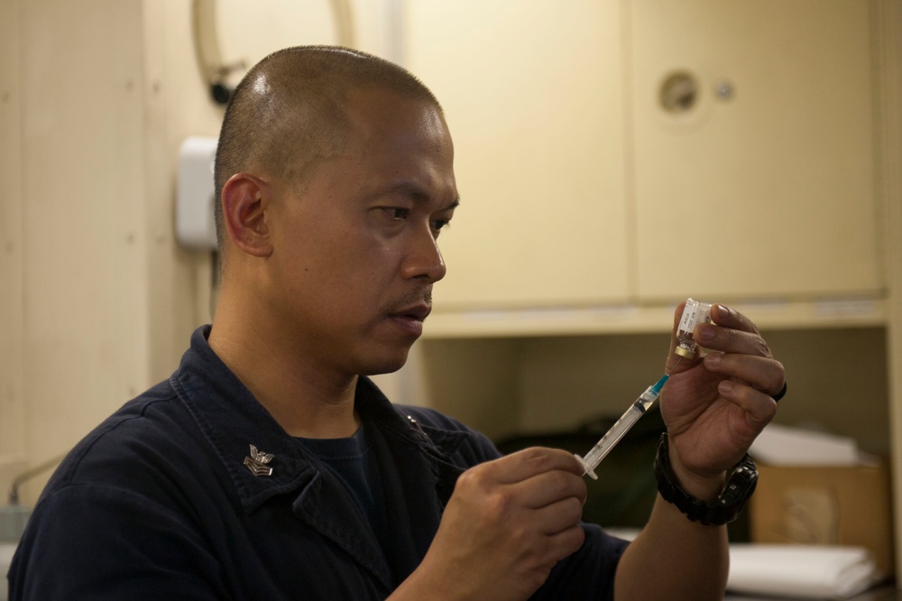 America Sailor prepares vaccinations for the crew