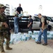 A Tactical Law Enforcement Team South, Miami, crewmember, Coast Guard Investigative Service Agents and Federal Air Marshal Service agents deliver water to people waiting to board flights at San Juan (Puerto Rico) International Airport, Sept. 26, 2017.