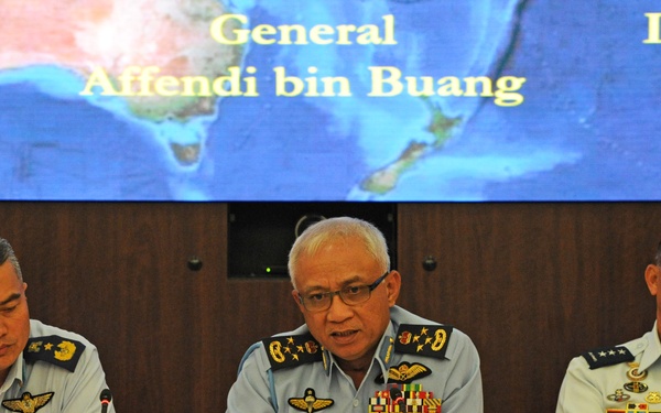 Three senior military officers in light blue uniforms are seated at a conference table during what appears to be a multinational military meeting or press conference. Name placards identify them as Brigadier General Shakell of the Royal Brunei Air Force, General Affendi of the Royal Malaysian Air Force, and Lieutenant General Fallorina of the Philippine Air Force. A large display screen behind them shows a map and their names.