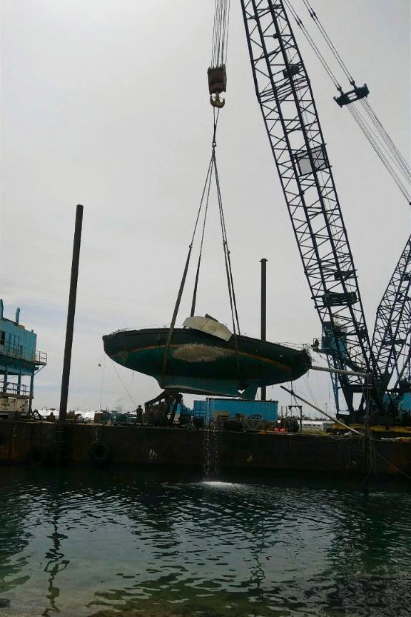 Response crews facilitate the hoist of a sailboat displaced by Hurricane Irma