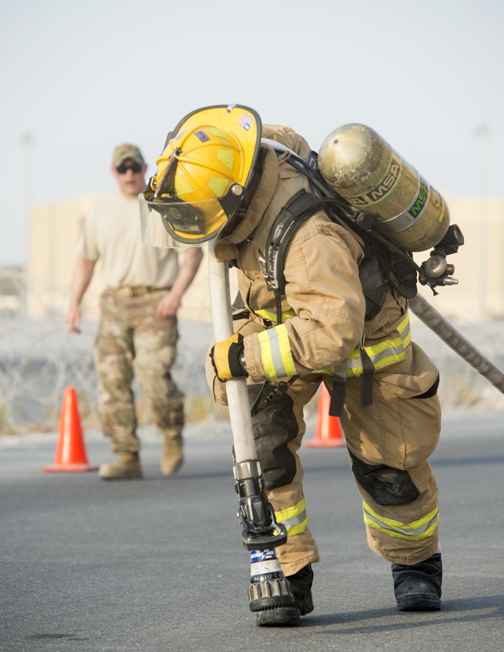 Firefighters with the U.S. Air Force and Qatar Emiri Air Force complete a firefighter combat challenge at Al Udeid Air Base