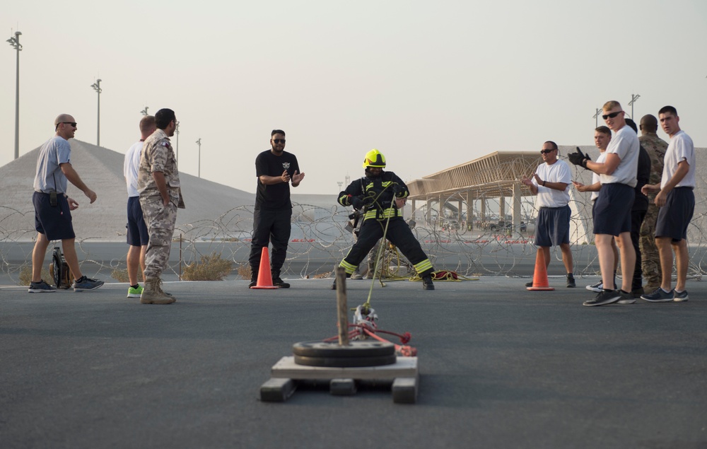 Firefighters with the U.S. Air Force and Qatar Emiri Air Force complete a firefighter combat challenge at Al Udeid Air Base