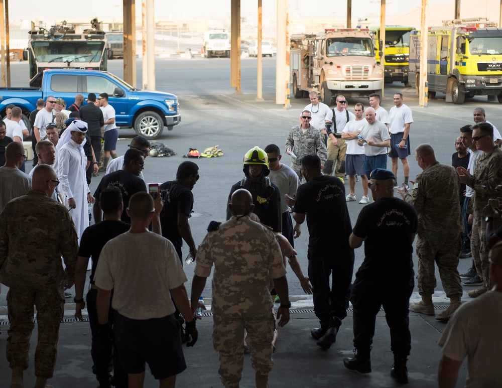 Firefighters with the U.S. Air Force and Qatar Emiri Air Force complete a firefighter combat challenge at Al Udeid Air Base