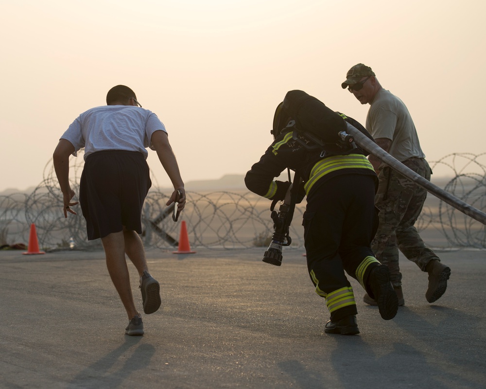 Firefighters with the U.S. Air Force and Qatar Emiri Air Force complete a firefighter combat challenge at Al Udeid Air Base