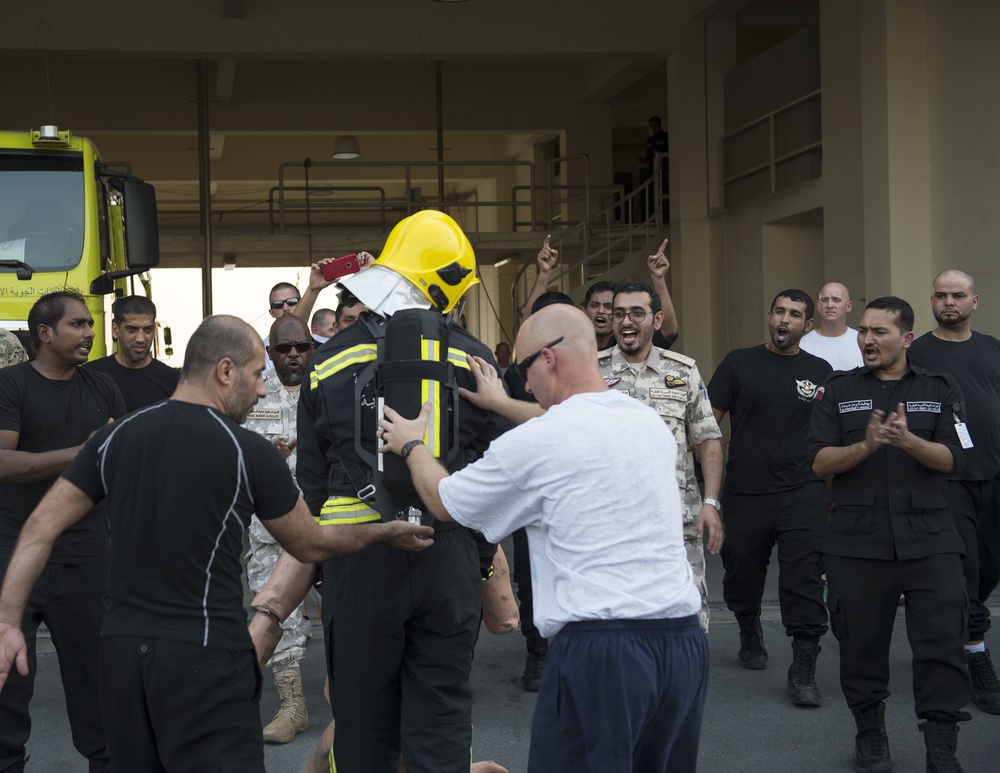 Firefighters with the U.S. Air Force and Qatar Emiri Air Force complete a firefighter combat challenge at Al Udeid Air Base