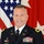 U.S. Army Maj. Gen. Stuart Risch A U.S. Army officer in dress blue uniform poses for an official military portrait. The name tag reads 'RISCH' and shoulder boards indicate the rank of Major General (two stars). The subject is photographed against a backdrop featuring the U.S. flag and a red two-star general officer flag.